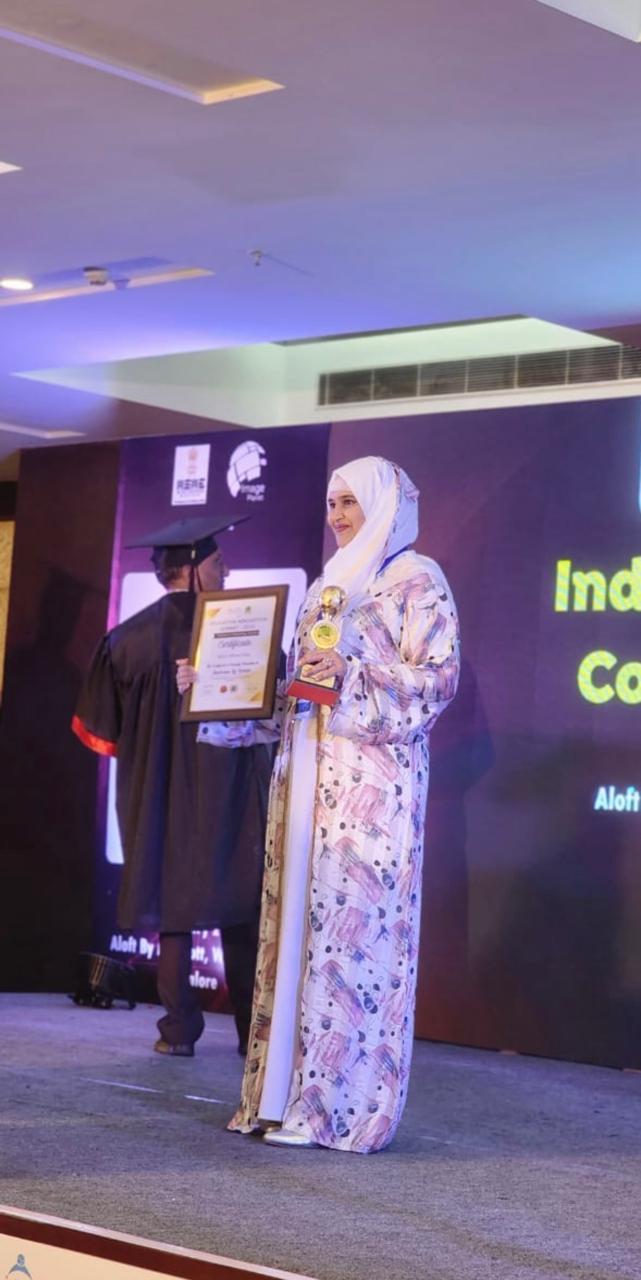Educator honoured with a trophy on stage