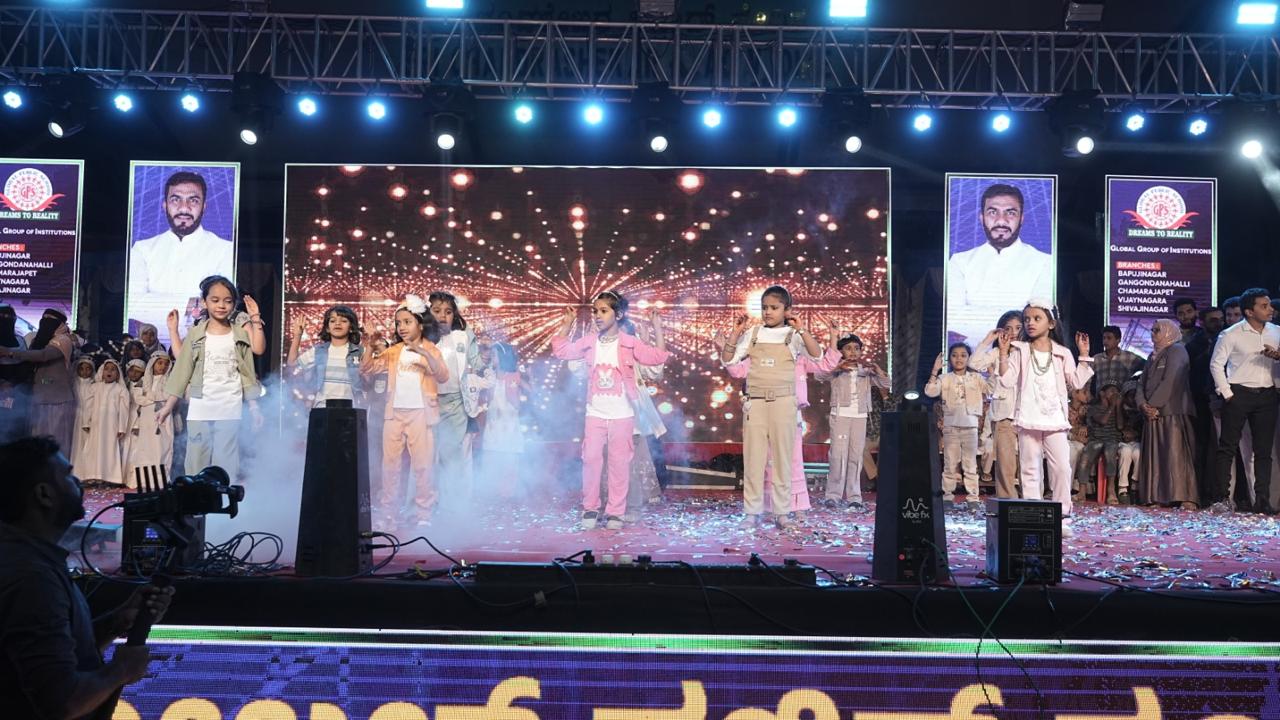 Children performing a group dance under stage lights