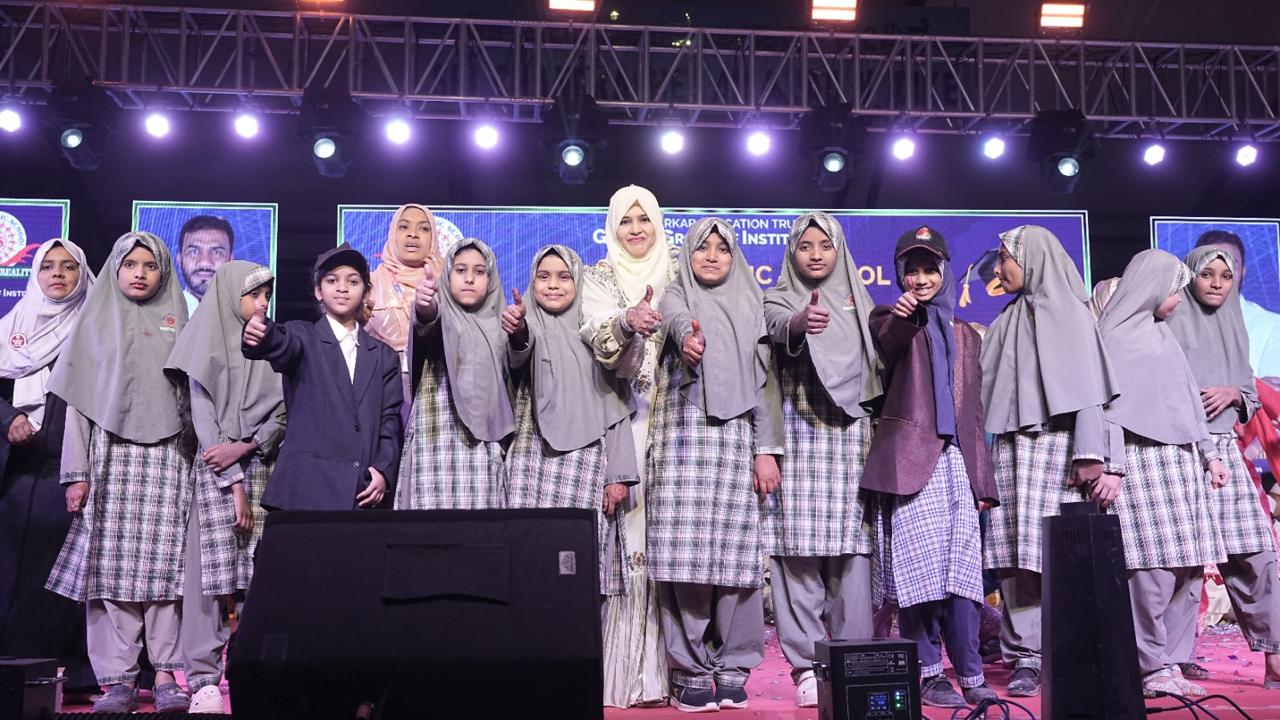 Students in uniform pose with their teacher