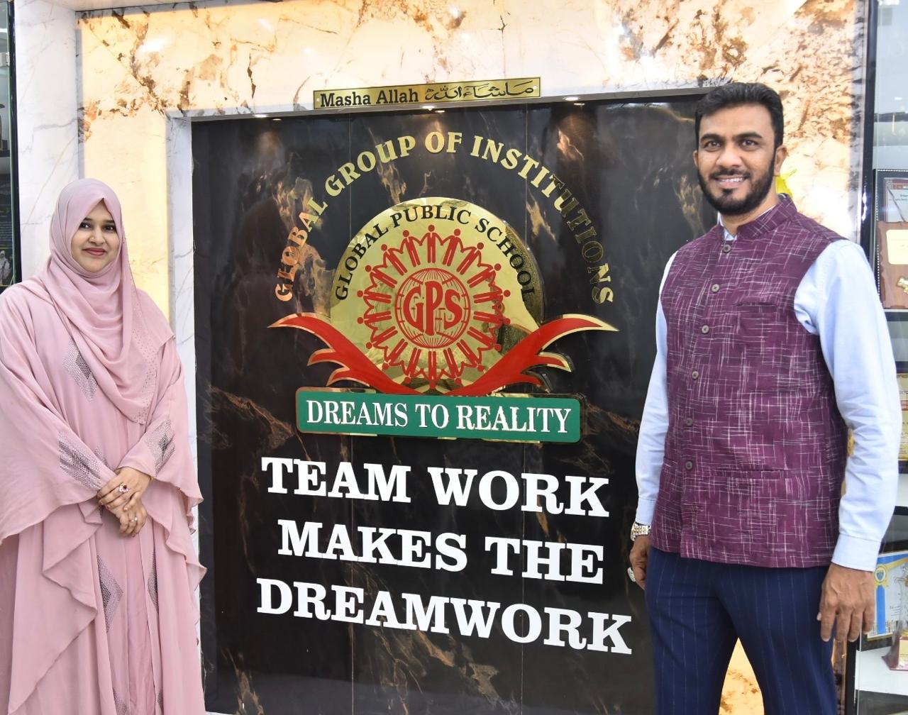 Educators beside the Global Public School emblem wall